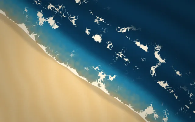 Seen from overhead, golden sand meets deep blue water along a diagonal shore edged with lacy white foam.