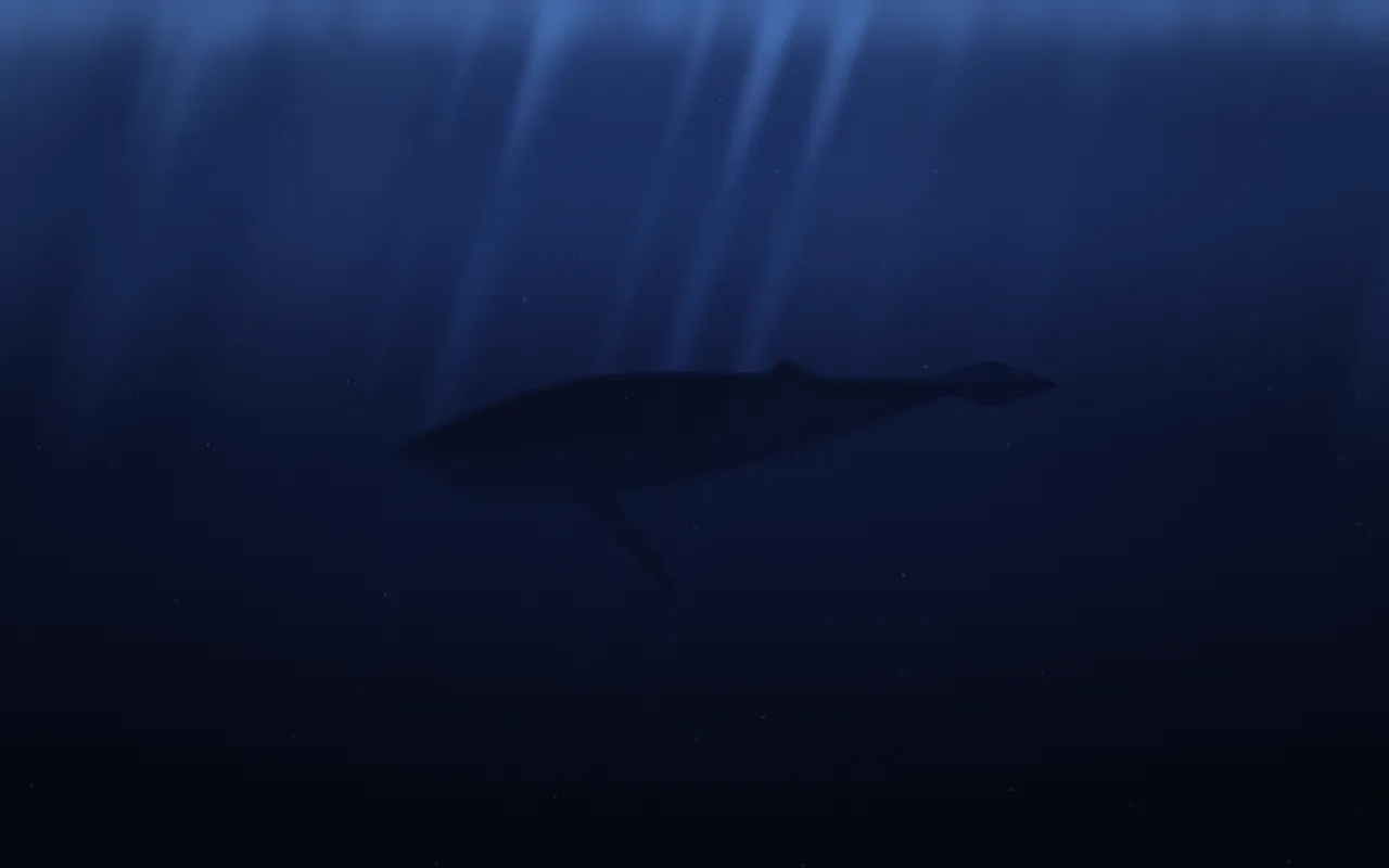 A humpback whale glides through deep navy water in near silhouette, with pale shafts of light falling from above.